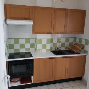 a kitchen with wooden cabinets and a stove top oven at Le T-Top in La Trinité-sur-Mer