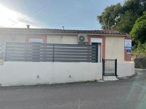 dom z ogrodzeniem i drzwiami garażowymi w obiekcie Gîte tout confort en Cévennes 3 étoiles w mieście Saint-Martin-de-Valgalgues