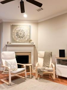 a living room with two chairs and a fireplace at Lovely Townhouse! in Auburn