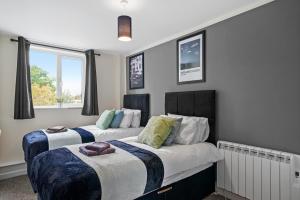 a bedroom with two beds and a window at 30 percent OFF! Modern and Stylish Gem of Southampton in Totton