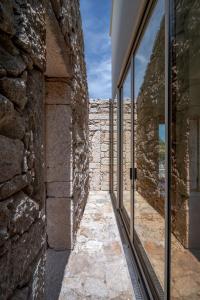 a stone wall with glass windows in a building at Casa do Macau in Monção +13 photos