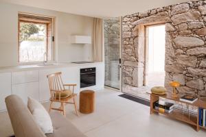 a kitchen and living room with a stone wall at Casa do Macau in Monção