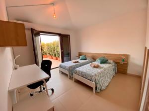 a hotel room with two beds and a desk and a desk at Penthouse Le Isole - Luxury rooftop retreat in Marsala