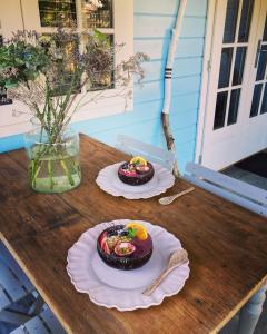 a wooden table with two plates of food on it at Bed and breakfast de Heg in Geldrop