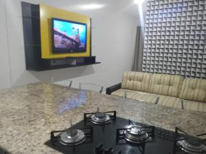 a living room with a table and a tv on a wall at Elegante Apartamento no centro de Curitiba in Curitiba