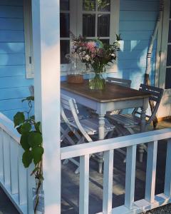 een tafel op een veranda met stoelen en bloemen bij Bed and breakfast de Heg in Geldrop
