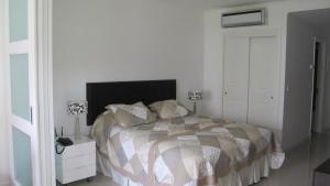 een slaapkamer met een bed en een nachtkastje met 2 lampen bij Green Park Hermosos Apartamentos Vista al Lago in Punta del Este