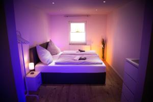 a purple bedroom with a bed with a window at WINETIME - modern - für 6 - Boxspringbetten - Netflix in Bellheim