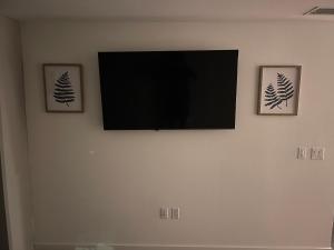 TV de pantalla plana en una pared con 2 imágenes en DTLA home away en Los Ángeles