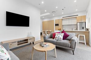 a living room with a couch and a tv at Academy Apartments in Masterton