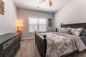 a bedroom with a bed and a dresser and a window at Nest - a cheerful 4 bedroom, 4.5 bath new townhome in Aggieland in College Station