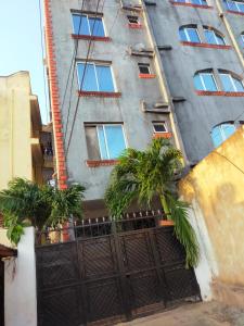 un bâtiment avec des palmiers en face de celui-ci dans l'établissement Phee home, à Mombasa