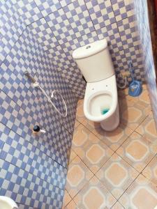 łazienka z toaletą w wyłożonej kafelkami ścianie w obiekcie Phee home w mieście Mombasa