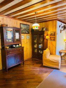 un salon avec une chaise jaune et une armoire dans l'établissement La Veranda nella Neve - Camigliatello Silano, à Camigliatello Silano