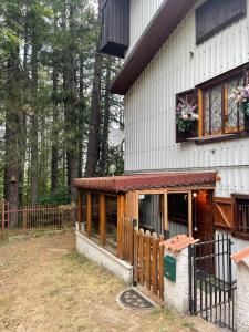 budynek z werandą z ogrodzeniem obok niego w obiekcie La Veranda nella Neve - Camigliatello Silano w mieście Camigliatello Silano