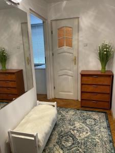 a bedroom with a bed and a mirror and a door at Green Apartment in Koło