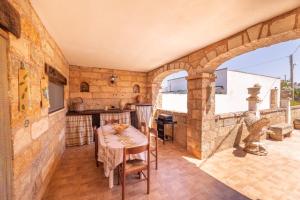 eine große Küche mit einem Tisch und einer Steinmauer in der Unterkunft bello e confortevole in Torre Suda