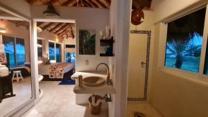 シワタネホにあるOceanfront Villa Zihuatanejoのバスルーム(シンク、鏡付)、ベッドルーム1室が備わります。