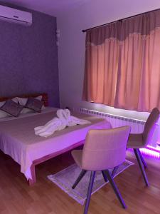 Cette chambre comprend un lit, une chaise et une fenêtre. dans l'établissement Sarajevo Apartments Casa United, à Sarajevo