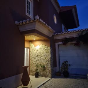 a house at night with a stone wall at Casa Dos Cedros in Lagos