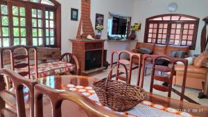 a living room with a table and chairs and a fireplace at Castelinho do Felix Guarujá Pernambuco in Guarujá
