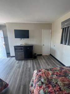 a hotel room with a bed and a flat screen tv at Keystone Motel in Norwalk