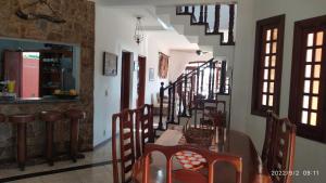 a dining room with a table and chairs and stairs at Castelinho do Felix Guarujá Pernambuco in Guarujá