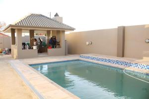 a swimming pool with a gazebo next to a house at Alu Boutique Hotel and Conference in Roodepoort