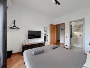 a bedroom with a large white bed and a flat screen tv at Appartamento di design in Rome