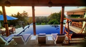 - une vue sur la piscine avec des chaises et une table dans l'établissement Cantik Villa, à Lovina