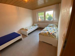 a small room with two beds and a window at Ferienwohnung Suhad in Ludwigshafen am Rhein