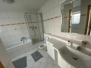 a bathroom with a sink and a toilet and a mirror at Ferienwohnung Suhad in Ludwigshafen am Rhein