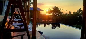 a reflection of the sunset in a swimming pool at Cantik Villa Tugu Belanda in Lovina