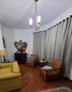 a living room with a couch and chairs and a chandelier at Recanto Esperança - Na Feirinha do Alto in Teresópolis