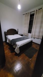 a bedroom with a bed and a window with curtains at Recanto Esperança - Na Feirinha do Alto in Teresópolis