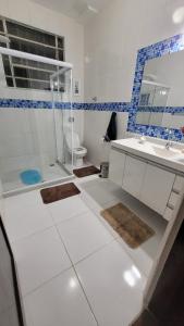 a bathroom with a shower and a sink and a toilet at Recanto Esperança - Na Feirinha do Alto in Teresópolis