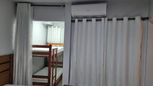 a room with two bunk beds and a curtain at ARARAS Apart Hotel - CTC in Caldas Novas +9 photos