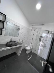 a bathroom with a toilet and a sink and a shower at Coral Village Family in Santa Bárbara de Samaná