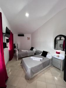 a bedroom with two beds in a room with a mirror at Coral Village Family in Santa Bárbara de Samaná