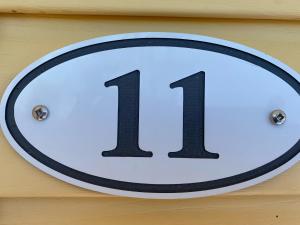 a sign with the number hanging on a wall at The Pines Motel and Cottages in Rustico