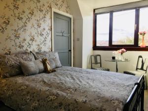 a bedroom with a bed with a teddy bear on it at Skye View-Skye Bridge House in Kyle of Lochalsh