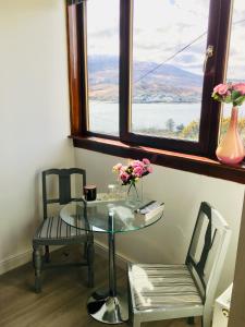 a glass table and chairs in a room with a window at Skye View-Skye Bridge House in Kyle of Lochalsh