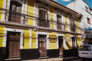a yellow and white building on the side of a street at Wake Up Hostel in La Paz