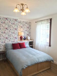 a bedroom with a bed with a floral wallpaper at Skye View-Skye Bridge House in Kyle of Lochalsh