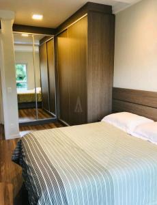 um quarto com uma cama grande e um espelho em Apartamento Executivo - No melhor lugar do América em Joinville