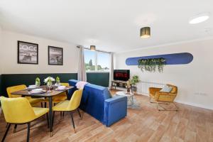 a living room with a blue couch and a table and chairs at 30 percent OFF! Exquisite Gems of Southampton! - 3 Bed in Totton