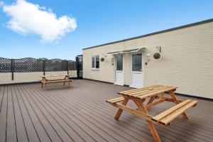 a wooden deck with two benches and a building at 30 percent OFF! Exquisite Gems of Southampton! - 3 Bed in Totton
