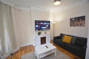 a living room with a couch and a tv at Cheerful 3 Bedroom Home in Greater London in London