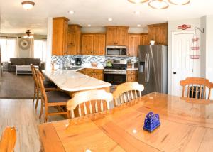 uma cozinha com uma mesa e um frigorífico de aço inoxidável em New Listing-Game room, Theater room, Amazing views em Cedar City