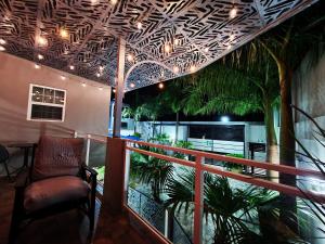 Cette chambre dispose d'un balcon avec une chaise et des palmiers. dans l'établissement Hotel Real de Lua, à Xilitla
